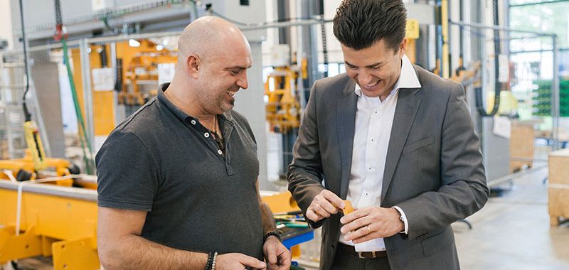 One of the managing directors visits the machine hall and talks to one of the employees