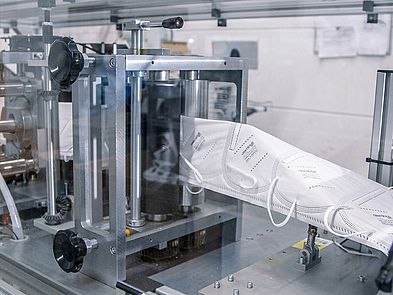 Detail of mask machine line with finished masks being folded