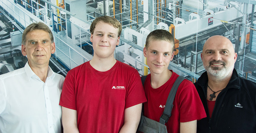 Two young mechanics apprentences with their instructors