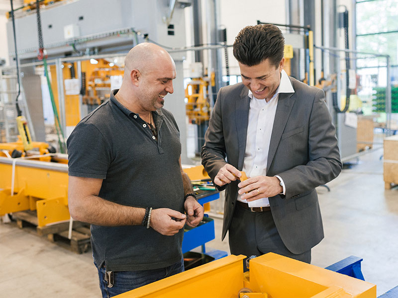 One of the managing directors visits the machine hall and talks to one of the employees