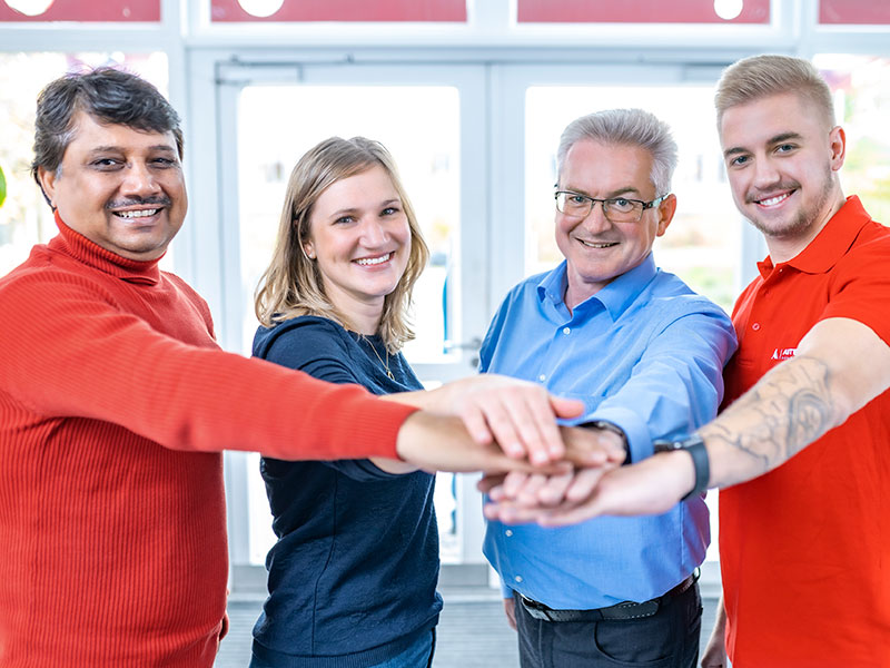 Diverse team members putting their hands together