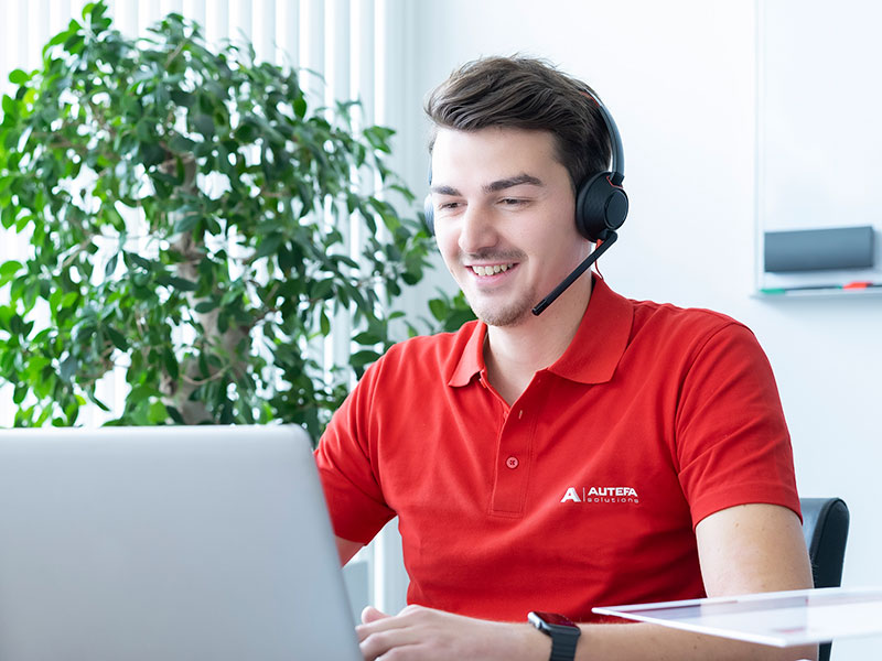 An employee in a red polo shirt answers service inquiries on the computer