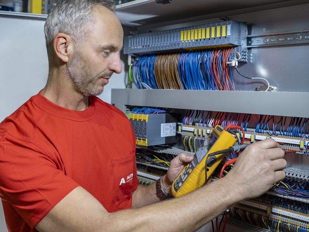  Retrofitting-Arbeit: Techniker modernisiert eine elektrische Schalttafel mithilfe eines Messgeräts
